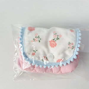 Detail of floral flip cover storage bag with pink quilted fabric and pompom trim decoration