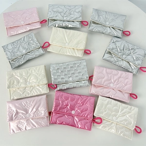 Detailed view of quilted PU coin purses in pink and silver with heart and bow patterns