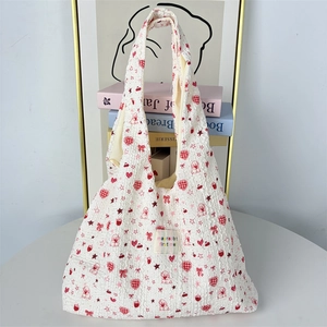 Dettaglio borsa tote in seersucker bianco con motivi di cuori e cani rossi ricamati