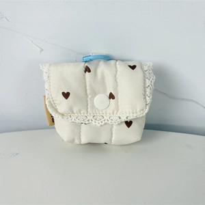 Close-up of quilted floral heart pattern earphone case with delicate white lace trim