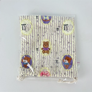 Close-up of quilted drawstring pouch with cartoon bear print in plastic packaging
