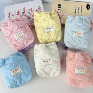 Detailed view of quilted cotton drawstring camera pouches in soft pastel macaron colors