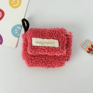 Detail of pink faux shearling plush earphone case with woven label and carry strap