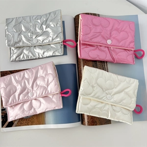 Detailed view of quilted heart pattern and snap closure on four glossy mini pouches