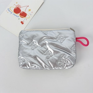 Detail of silver metallic pouch with 3D embossed bows and pink lanyard attachment