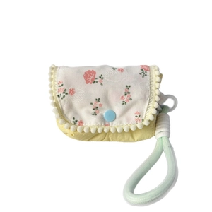 Floral quilted mini pouch with pom-pom trim and green rope handle for women