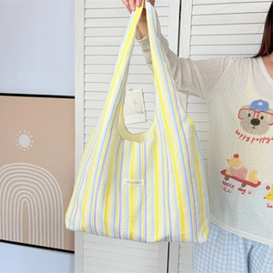 Detail showing colorful vertical stripes and brand label on fabric tote bag