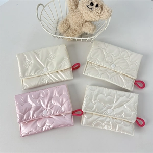 Close-up of quilted PU leather mini pouches with heart and bow patterns and elastic loops