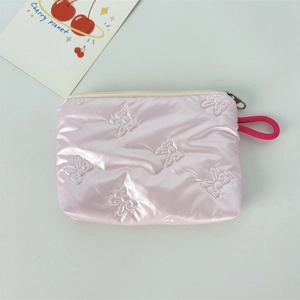 Pink quilted makeup bag with bow pattern texture and convenient carry strap