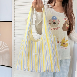 Detail of colorful rainbow striped tote bag with seersucker texture and brand logo