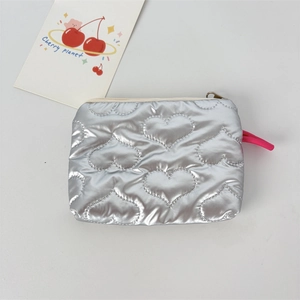 Detail of silver heart-quilted PU leather coin purse with zipper and pink puller