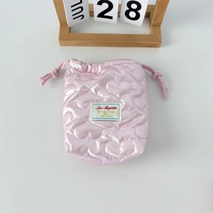 Detailansicht der rosa gesteppten Kordelzugtasche mit Herzmustern und Satin-Oberfläche