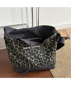 Detail of leopard print tote bag with Bonne journée slogan on blue denim fabric