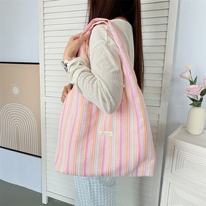 Detail showing pink and orange striped seersucker fabric texture on a large tote bag