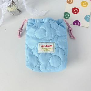 Close-up of light blue quilted drawstring camera bag with Love Mayrabbit woven label