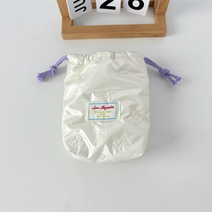 Detailansicht der weißen PU-Tasche mit geprägten Schleifenmustern und lila Kordelzug