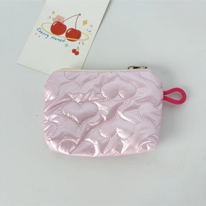 Detail of pink heart-quilted PU leather coin purse with zipper and metal glossy finish
