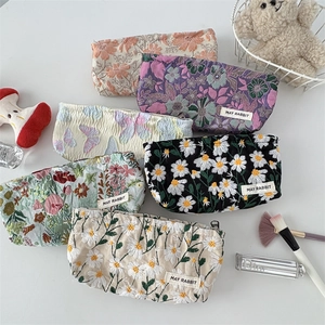Flat lay view of jacquard floral cosmetic bags with embroidery and metal zippers
