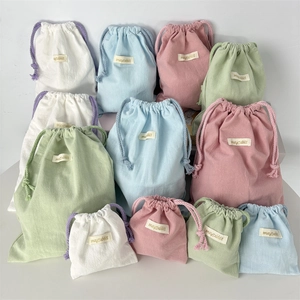 Detail view of multi-color drawstring crepe storage bags in various sizes for travel