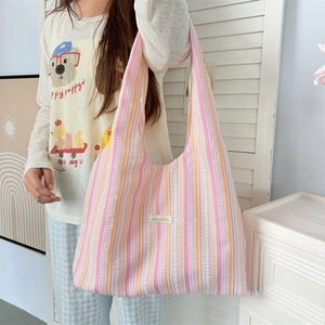Detail of colorful vertical striped tote bag featuring pink and orange textured fabric