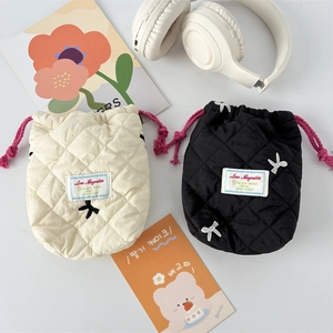 Quilted drawstring camera pouches in black and cream with bow embroidery and cord closure