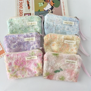 Flat lay of six floral lace pouches in pastel colors with silk ribbon zipper pulls