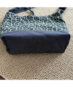 Detail view of the wide bottom and leopard print canvas stitching on this shoulder tote bag