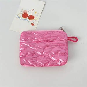 Detail of pink glossy makeup pouch with heart quilted texture and zipper closure