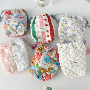 Flat lay of quilted cotton drawstring pouches in various floral and striped patterns