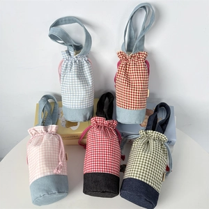 Detailed view of five plaid water bottle sleeves with drawstring closure and hand straps