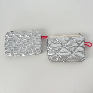 Detail view of silver quilted makeup bags with square and diamond stitch patterns