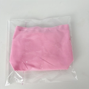 Detailed view of pink canvas storage bag inside its protective plastic packaging