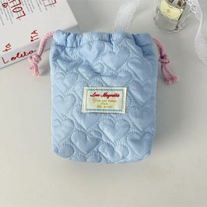 Detailansicht der hellblauen gesteppten Kordelzugtasche mit Herzmuster und Spitze