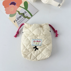 Detail of quilted camera pouch with pink drawstring and cute black ribbon on white background