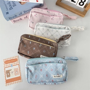 Close-up of floral corduroy pencil cases in pink, beige, brown, and light blue colors