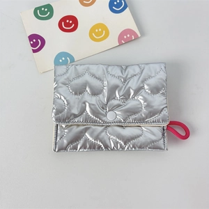 Detail of silver metallic quilted mini pouch with heart patterns and button closure