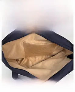 Detailed interior of the navy nylon tote bag showing the light brown lining and storage pocket