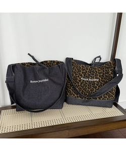 Detail showing leopard print and blue denim tote bags with white lettering on top