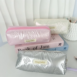 Quilted bow embroidery pencil cases in pink, beige, and silver with metal texture
