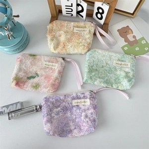 Detail of floral lace mini pouches with satin handle for lipstick and coin storage
