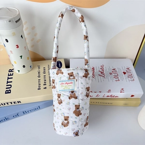 Detailed close-up of a quilted cotton cup holder featuring a cute brown bear print