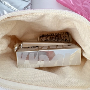 Close-up of pink quilted makeup pouch showing interior storage with lipsticks and lining