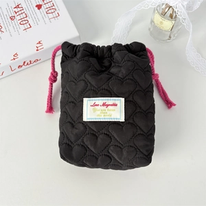 Detail der Kosmetiktasche mit Herzsteppung, rosa Kordelzug und gewebtem Etikett