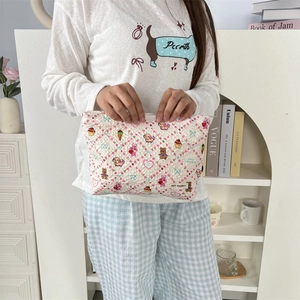 Détail de la trousse de maquillage matelassée avec motifs de dessins animés colorés