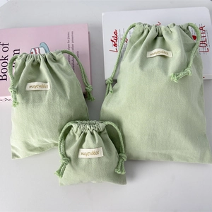 Three green crepe cotton drawstring bags in various sizes for travel and home storage