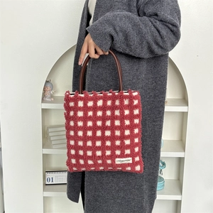 Détail du sac cabas en peluche à damier rouge et blanc avec poignées en cuir brun