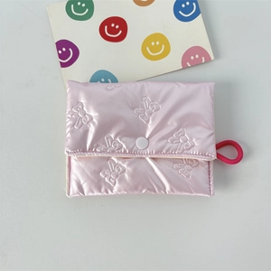 Detail of pink quilted coin purse with bow embossing and white button closure
