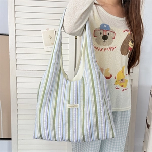 Detail of multi-color striped tote bag with light green, blue, and purple fabric textures
