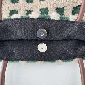 Détail du sac cabas à damier montrant le fermoir magnétique et la doublure noire