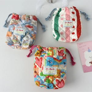 Detail of three quilted cotton drawstring pouches with vintage patterns and floral textures
